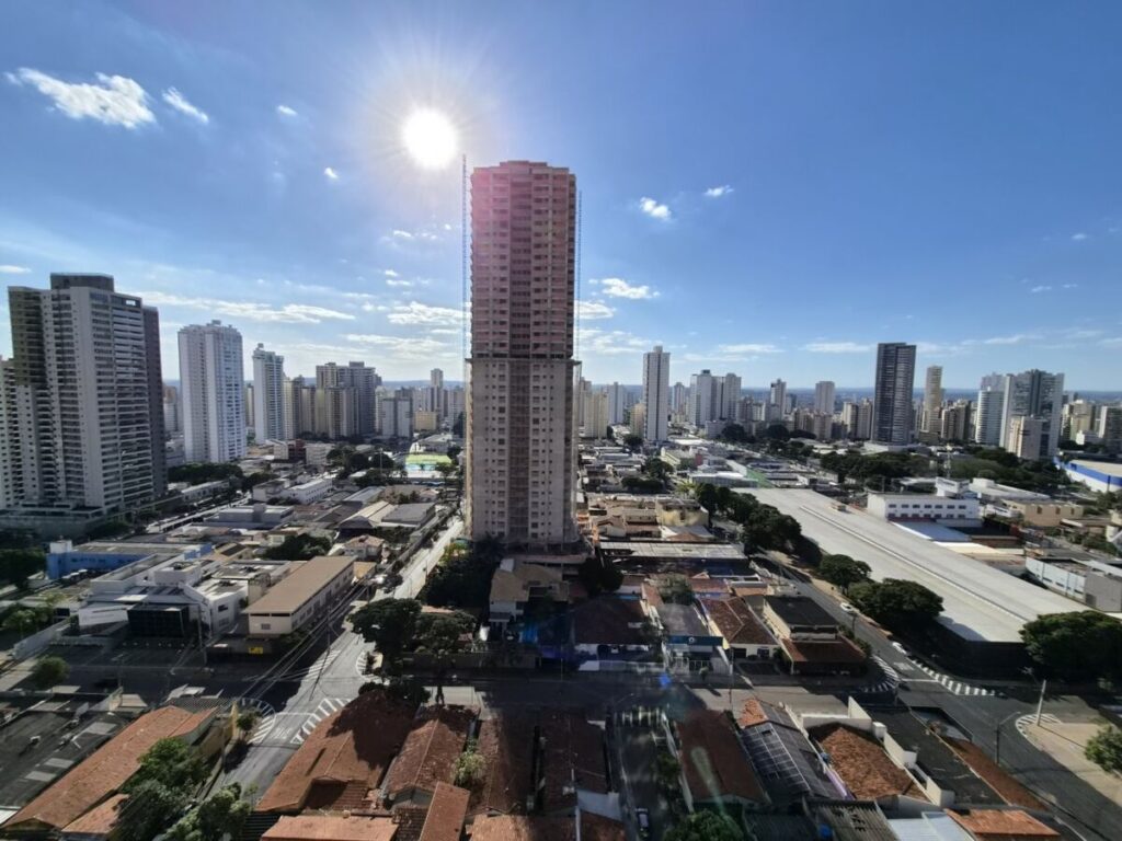 Vista aérea de prédios e casas do Setor Bueno, em Goiânia, sob céu azul com sol