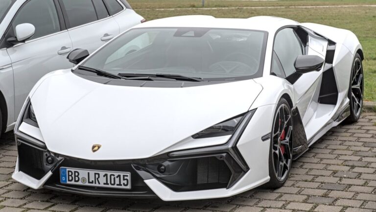 Lamborghini Revuelto branca estacionada, vista de frente e de lado, ao lado de outro carro