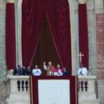 O papa Leão XIV acena da sacada da Basílica de São Pedro, ao lado de outros religiosos, em sua primeira aparição como papa