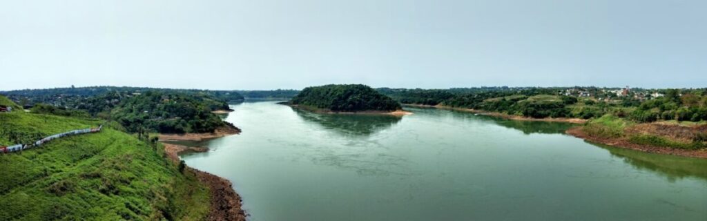 Vista panorâmica do rio Paraná, entre colinas verdes, na divisa entre Brasil e Paraguai