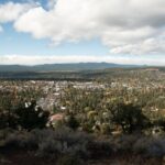 Vista da cidade de Bend, no Oregon, a partir de uma colina, com casas, árvores e montanhas ao fundo